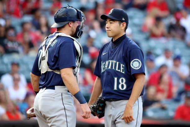 Yusei Kikuchi of the Seattle Mariners talks with Cal Raleigh from the mound during the second inning against the Los Angeles Angels at Angel Stadium...