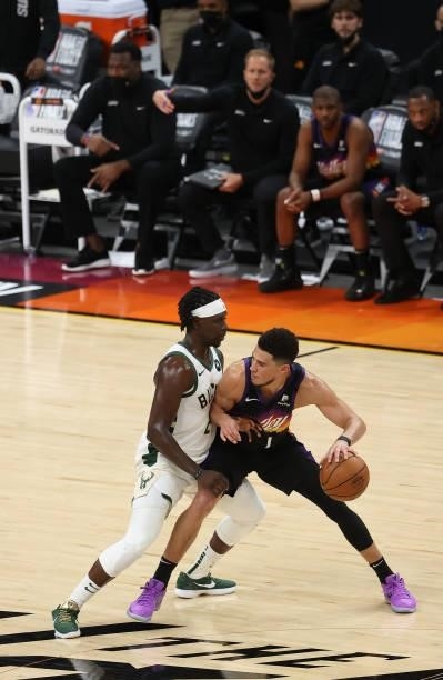 Jrue Holiday of the Milwaukee Bucks defends as Devin Booker of the Phoenix Suns brings the ball up court during the second half in Game Five of the...