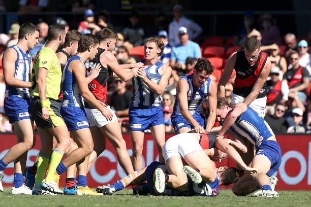Players scuffle during the round 18 AFL match between North Melbourne Kangaroos and Essendon Bombers at Metricon Stadium on July 18, 2021 in Gold...