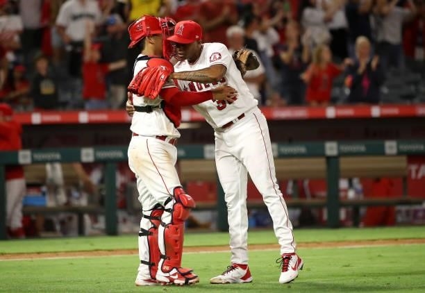 Raisel Iglesias and Kurt Suzuki of the Los Angeles Angels celebrate their 9-4 win against the Seattle Mariners after the game at Angel Stadium of...