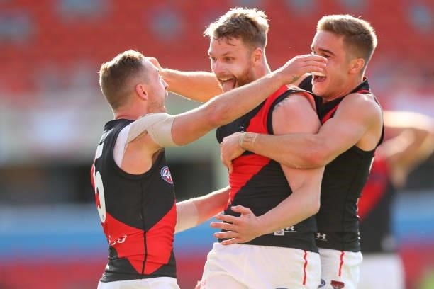 Devon Smith of Essendon celebrates with Jake Stringer of Essendon and team mates during the round 18 AFL match between North Melbourne Kangaroos and...