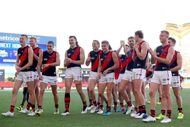 Essendon players celebrate victory during the round 18 AFL match between North Melbourne Kangaroos and Essendon Bombers at Metricon Stadium on July...