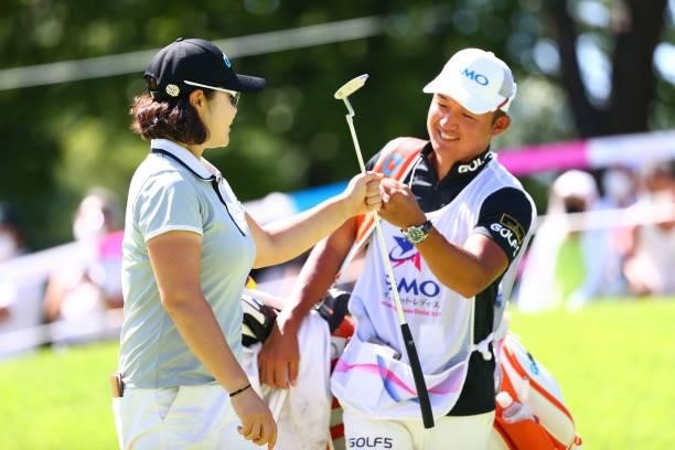 Min-young Lee of South Korea fist bumps with her caddie after holing out with the birdie on the 18th green during third round of the GMO Internet...