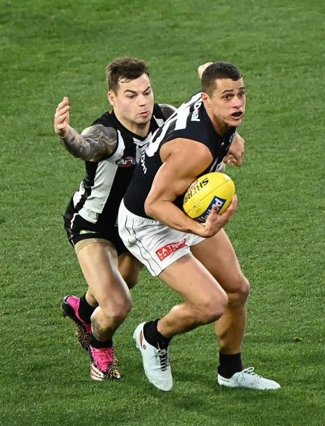 Ed Curnow of the Blues is tackled by Jamie Elliott of the Magpies during the round 18 AFL match between Collingwood Magpies and Carlton Blues at...