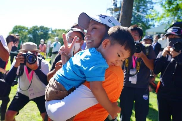 Winner Maiko Wakabayashi of Japan holding her son poses for photographs after winning the tournament following final round of the GMO Internet Ladies...