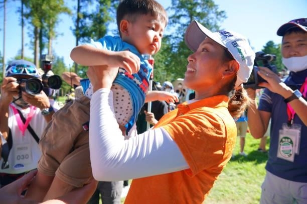 Winner Maiko Wakabayashi of Japan lifts her son after winning the tournament following final round of the GMO Internet Ladies Samantha Thavasa Global...