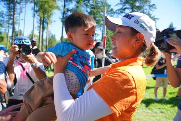 Winner Maiko Wakabayashi of Japan lifts her son after winning the tournament following final round of the GMO Internet Ladies Samantha Thavasa Global...