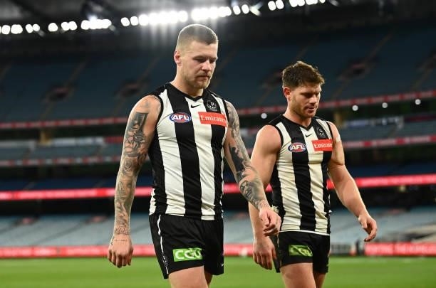 Jordan De Goey and Taylor Adams of the Magpies walk off after the Magpies were defeated by the Blues during the round 18 AFL match between...