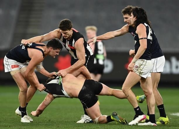 Nic Newman of the Blues and Taylor Adams of the Magpies wrestle during the round 18 AFL match between Collingwood Magpies and Carlton Blues at...