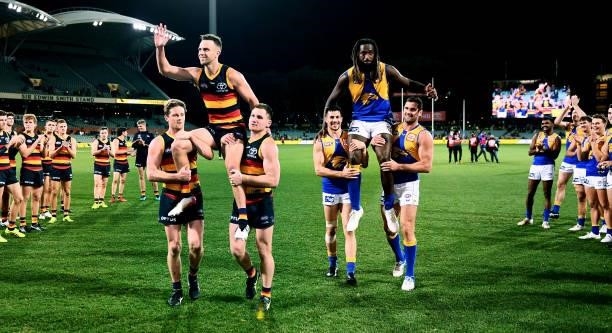Brodie Smith of the Crows chaired off by Rory Sloane and Rory Laird of the Crows and Nic Naitanui of the Eagles chaird off by Liam Duggan and Jack...