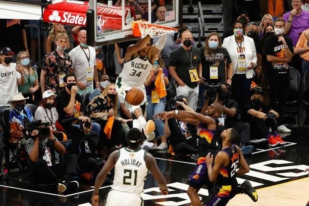 Giannis Antetokounmpo of the Milwaukee Bucks slam dunks the ball over Chris Paul of the Phoenix Suns late in the second half of game five of the NBA...