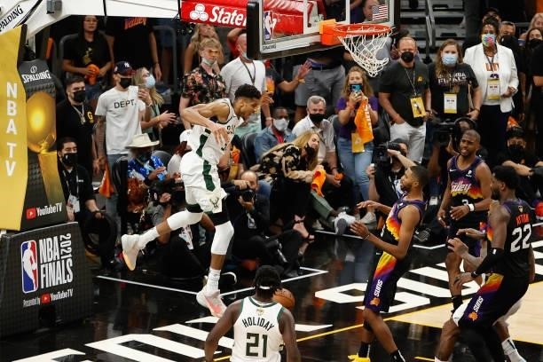Giannis Antetokounmpo of the Milwaukee Bucks slam dunks the ball over Mikal Bridges of the Phoenix Suns late in the second half of game five of the...
