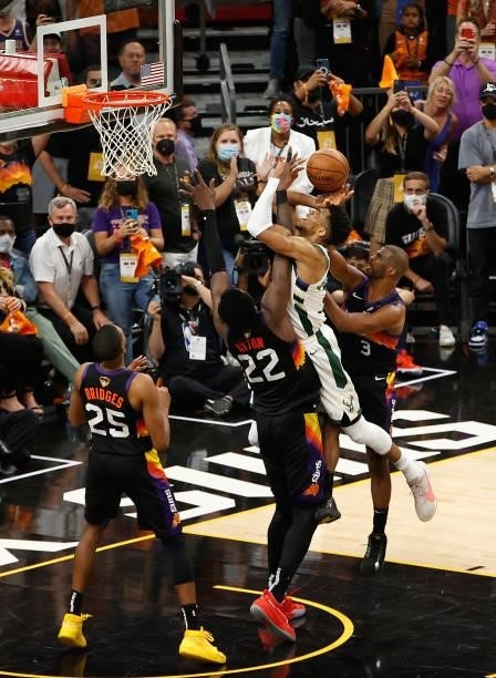 Giannis Antetokounmpo of the Milwaukee Bucks is fouled by Chris Paul of the Phoenix Suns as he shoots in the second half of game five of the NBA...