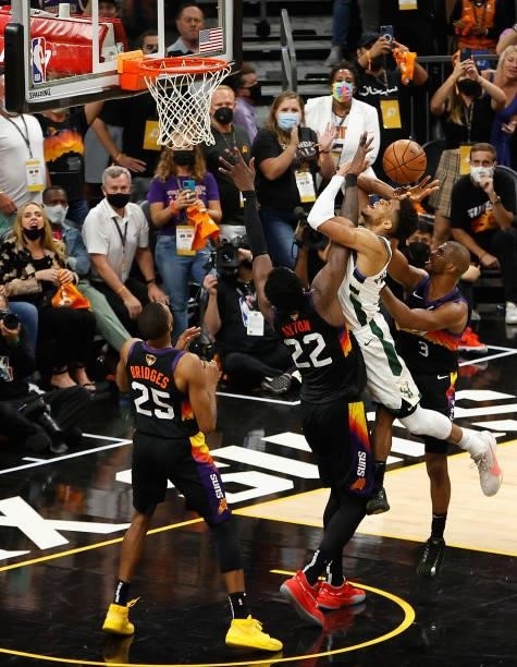 Giannis Antetokounmpo of the Milwaukee Bucks is fouled by Chris Paul of the Phoenix Suns as he shoots in the second half of game five of the NBA...