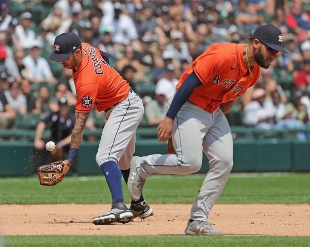 Carlos Correa of the Houston Astros bobbles the ball as Abraham Toro runs past him allowing a single to Andrew Vaughn of the Chicago White Sox in the...