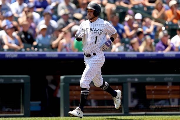 Garrett Hampson of the Colorado Rockies scores on a Charlie Blackmon RBI single against the Los Angeles Dodgers in the first inning at Coors Field on...