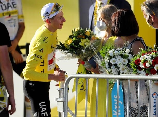 Race leader's Yellow Jersey Tadej Pogacar of Slovenia and UAE Team Emirates gives the bouquet of flowers to his girlfriend Urska Zigart after the...