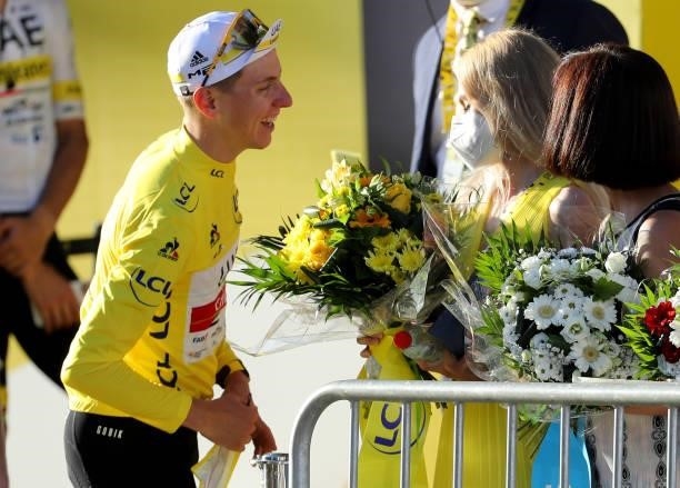 Race leader's Yellow Jersey Tadej Pogacar of Slovenia and UAE Team Emirates gives the bouquet of flowers to his girlfriend Urska Zigart after the...