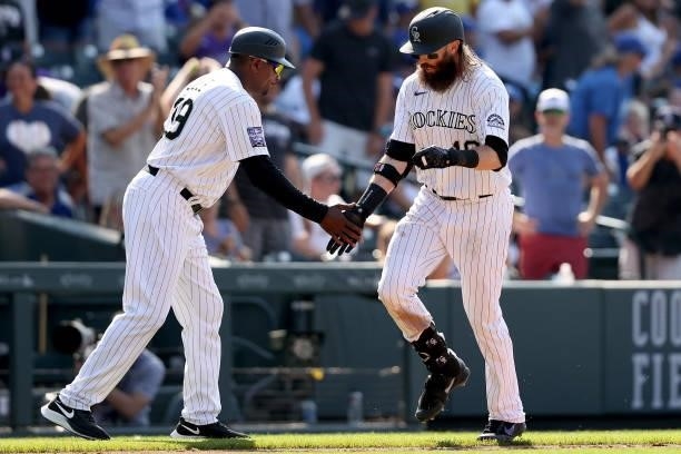 Charlie Blackmon of the Colorado Rockies is congratulated by Stu Cole as he circles the bases after hitting a walk off home run against the Los...