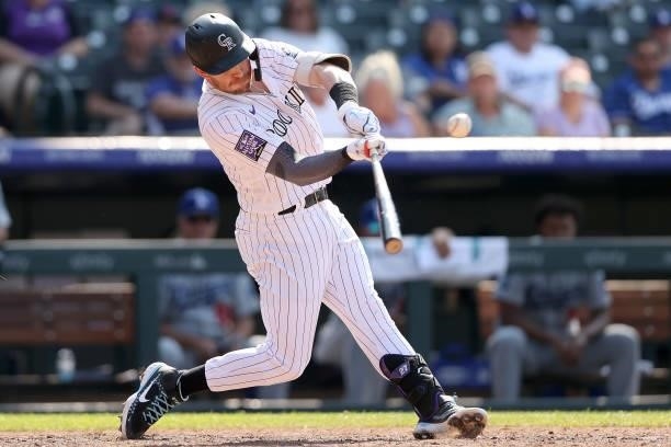 Trevor Story of the Colorado Rockies hits a sacrifice fly to tie the game against the Los Angeles Dodgers in the tenth inning at Coors Field on July...