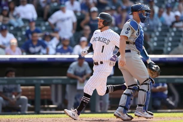 Garrett Hampson of the Colorado Rockies scores on a Trevor Story sacrifice fly to tie the game against the Los Angeles Dodgers in the tenth inning at...