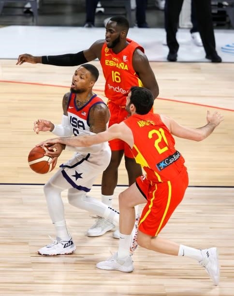 Damian Lillard of the United States drives against Usman Garuba and Alex Abrines of Spain during an exhibition game at Michelob ULTRA Arena ahead of...