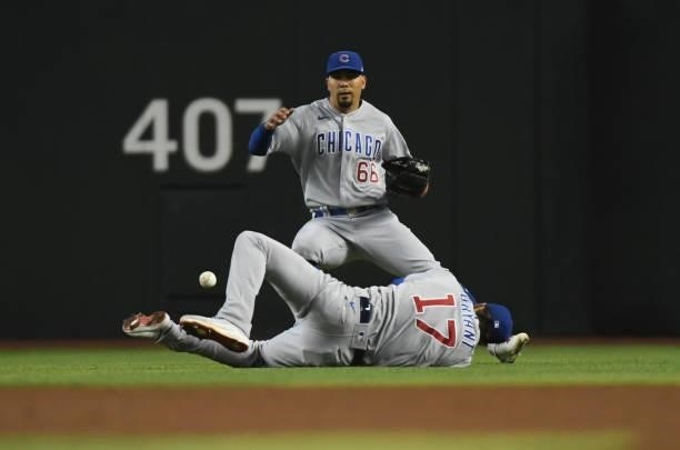 Kris Bryant and Rafael Ortega of the Chicago Cubs cannot make a catch on a fly ball hit by Daulton Varsho of the Arizona Diamondbacks during the...