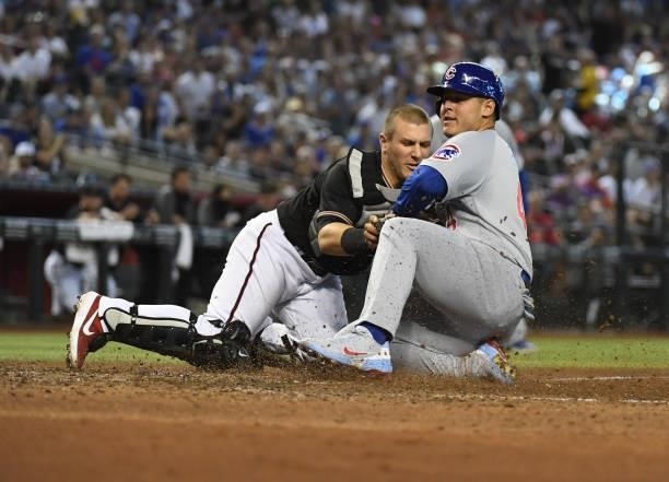 Anthony Rizzo of the Chicago Cubs is tagged out at home by Daulton Varsho of the Arizona Diamondbacks while trying to score on a ground ball hit by...