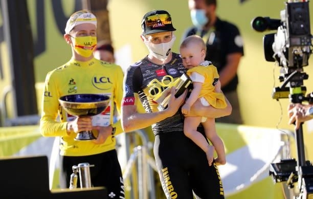 Second place of the Tour Jonas Vingegaard of Denmark and Jumbo - Visma holding his baby, winner's Yellow Jersey Tadej Pogacar of Slovenia and UAE...