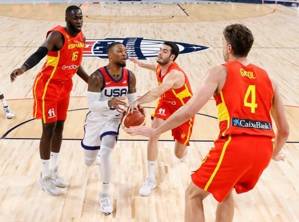 Damian Lillard of the United States passes under pressure from Usman Garuba, Alex Abrines and Pau Gasol of Spain during an exhibition game at...