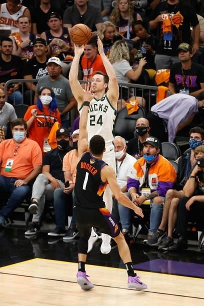 Pat Connaughton of the Milwaukee Bucks puts up a three-point shot over Devin Booker of the Phoenix Suns in the second half of game five of the NBA...