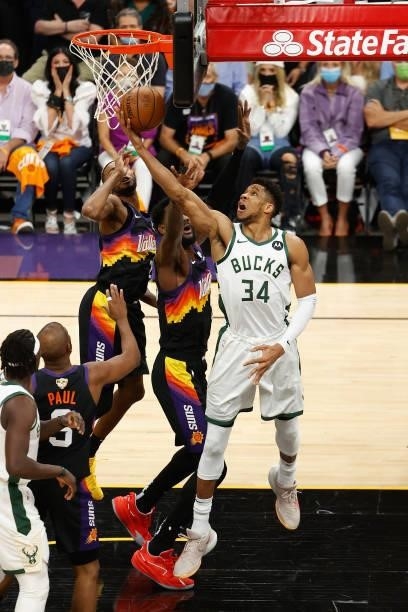 Giannis Antetokounmpo of the Milwaukee Bucks puts up a shot past Deandre Ayton of the Phoenix Suns in the first half of game five of the NBA Finals...