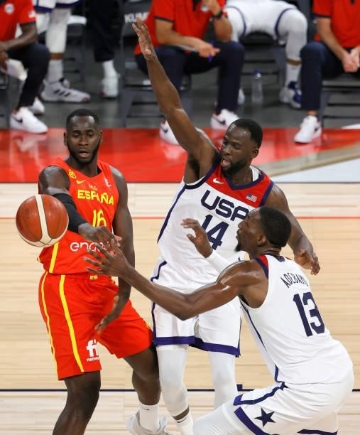 Usman Garuba of Spain passes under pressure from Draymond Green and Bam Adebayo of the United States during an exhibition game at Michelob ULTRA...