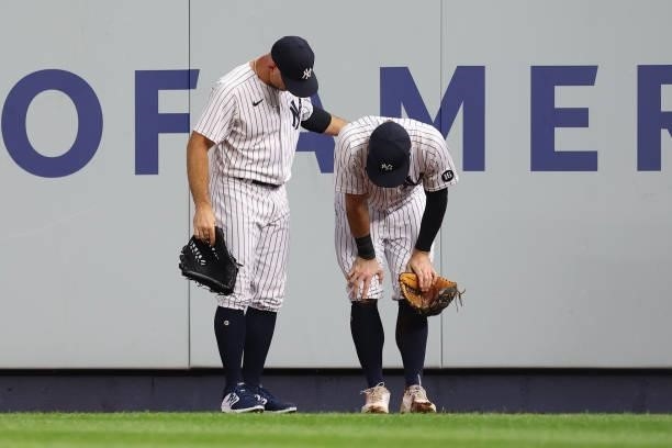 Center fielder Brett Gardner checks on right fielder Trey Amburgey of the New York Yankees who crashed into the wall in an attempt to catch a double...