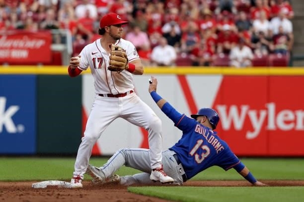 Kyle Farmer of the Cincinnati Reds turns a double play past Luis Guillorme of the New York Mets in the second inning at Great American Ball Park on...
