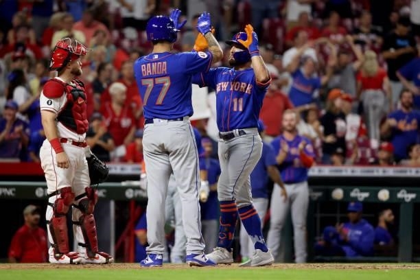 Anthony Banda and Kevin Pillar of the New York Mets celebrate after Pillar hit a home run in the eleventh inning against the Cincinnati Reds at Great...