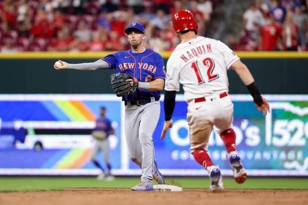 Jeff McNeil of the New York Mets turns a double play past Tyler Naquin of the Cincinnati Reds in the tenth inning at Great American Ball Park on July...