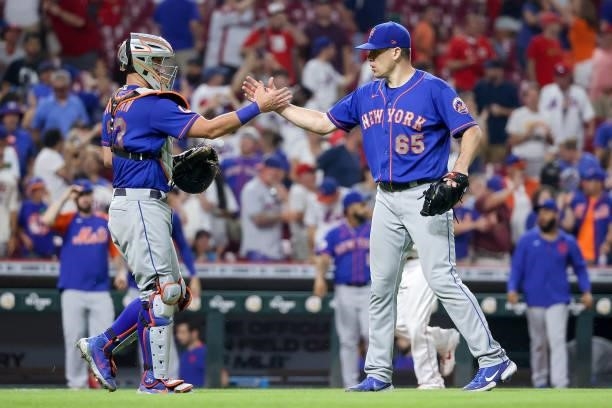 James McCann and Trevor May of the New York Mets celebrate after beating the Cincinnati Reds 15-11 in eleven innings at Great American Ball Park on...