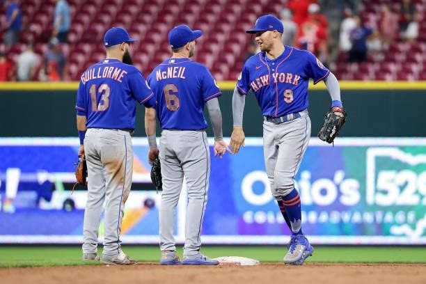 Luis Guillorme, Jeff McNeil, and Brandon Nimmo of the New York Mets celebrate after beating the Cincinnati Reds 15-11 in eleven innings at Great...
