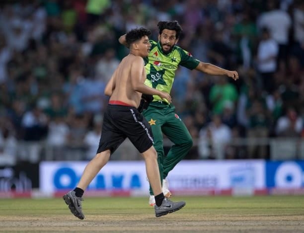 Hasan Ali of Pakistan wards off a pitch invader during the 3rd T20I between England and Pakistan at Emirates Old Trafford on July 20, 2021 in...