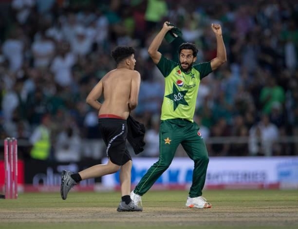 Hasan Ali of Pakistan wards off a pitch invader during the 3rd T20I between England and Pakistan at Emirates Old Trafford on July 20, 2021 in...