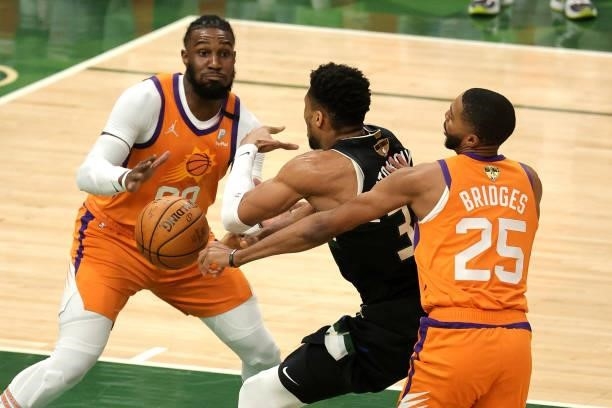 Giannis Antetokounmpo of the Milwaukee Bucks looses the ball against Jae Crowder and Mikal Bridges of the Phoenix Suns in Game Six of the NBA Finals...