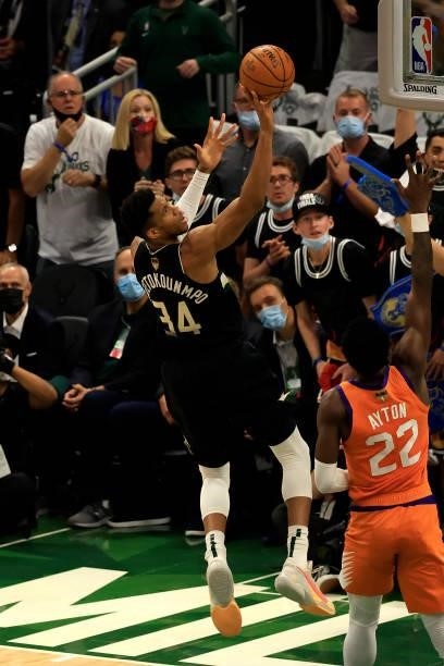 Giannis Antetokounmpo of the Milwaukee Bucks goes up for a shot against Deandre Ayton of the Phoenix Suns in Game Six of the NBA Finals at Fiserv...