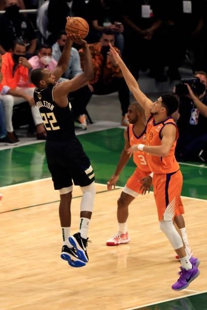 Khris Middleton of the Milwaukee Bucks shoots against Devin Booker of the Phoenix Suns during the first half in Game Six of the NBA Finals at Fiserv...