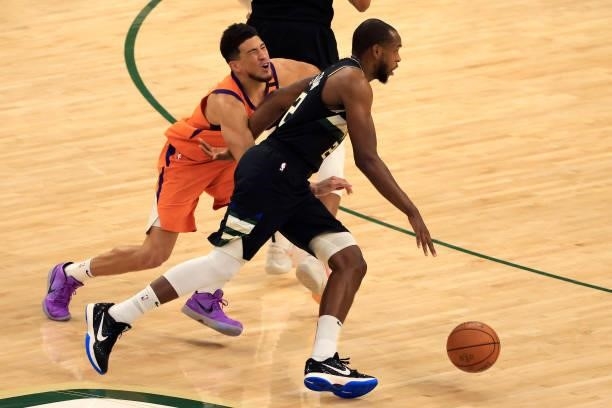 Khris Middleton of the Milwaukee Bucks drives to the basket against Devin Booker of the Phoenix Suns during the first half in Game Six of the NBA...