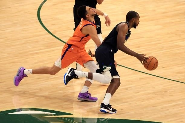 Khris Middleton of the Milwaukee Bucks drives to the basket against Devin Booker of the Phoenix Suns during the first half in Game Six of the NBA...