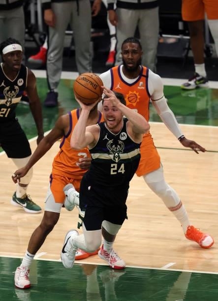 Pat Connaughton of the Milwaukee Bucks passes against Chris Paul of the Phoenix Suns during the first half in Game Six of the NBA Finals at Fiserv...