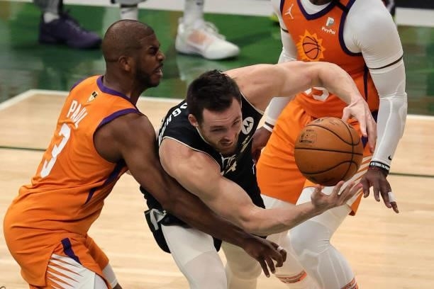 Pat Connaughton of the Milwaukee Bucks is pressured by Chris Paul of the Phoenix Suns during the first half in Game Six of the NBA Finals at Fiserv...