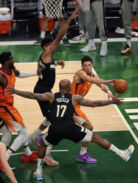 Devin Booker of the Phoenix Suns passes against P.J. Tucker of the Milwaukee Bucks during the first half in Game Six of the NBA Finals at Fiserv...