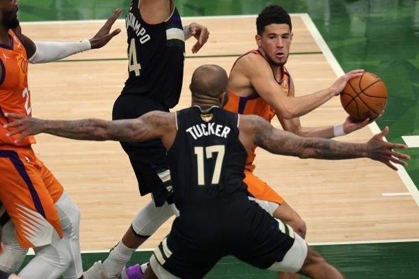 Devin Booker of the Phoenix Suns looks to pass against P.J. Tucker of the Milwaukee Bucks during the first half in Game Six of the NBA Finals at...